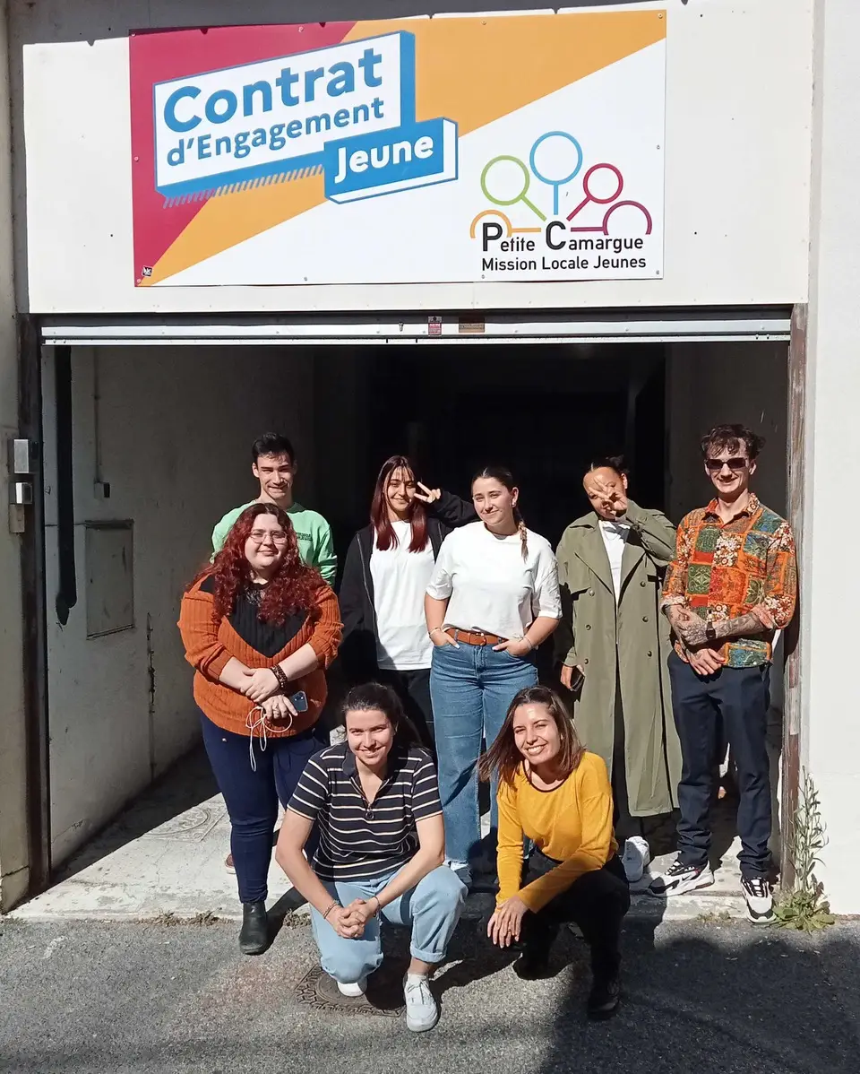 Un groupe de jeunes, hommes et femmes, souriants devant une bannière indiquant "Contrat d'Engagement Jeune" et "Mission Locale Jeunes Petite Camargue".