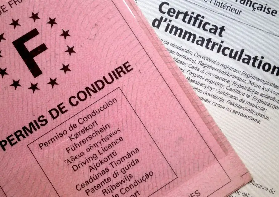 Permis de conduire français de couleur rose avec un certificat d'immatriculation, représentant les documents officiels nécessaires pour conduire en France.